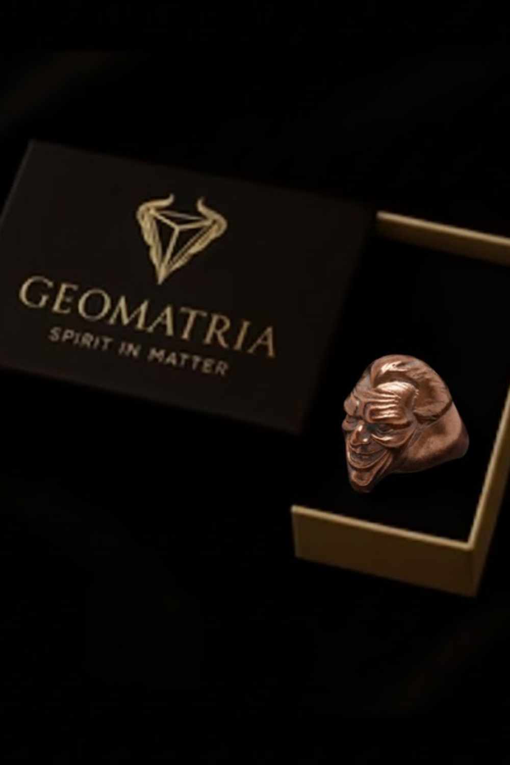 a ring box with a ring inside, and the box is labeled "Geomatria Spirit in Matter".