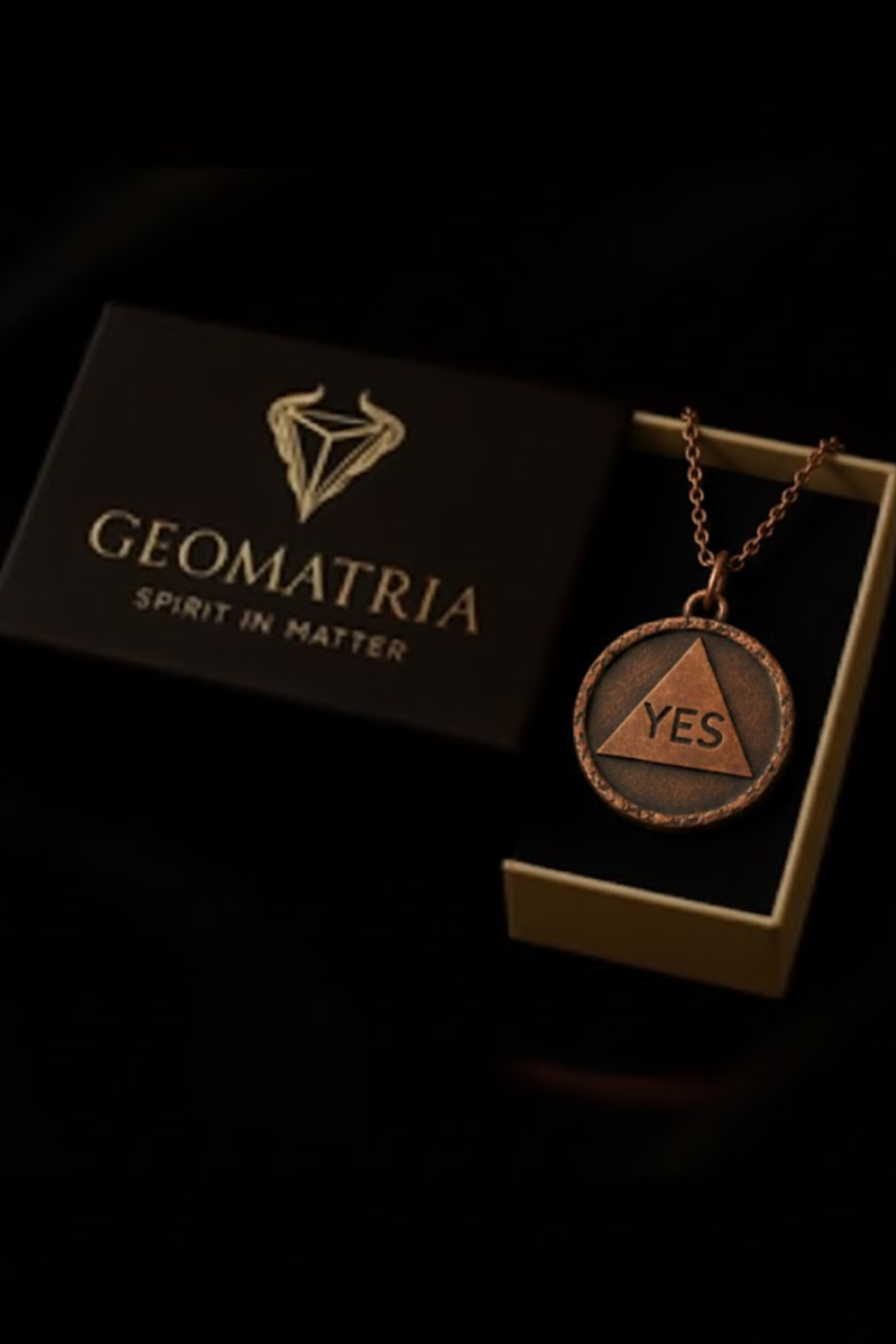 a necklace with a pendant, placed inside a box with the word "Geomatria" written on it.
