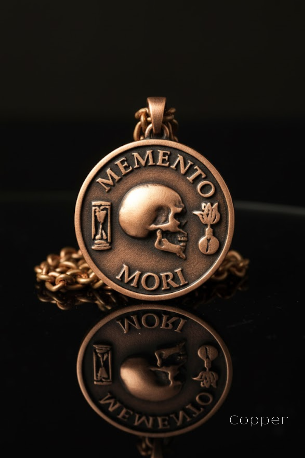 A copper-colored pendant necklace with a circular medallion featuring a skull and the Latin phrase "Memento mori" (which means " remembrance of death ").