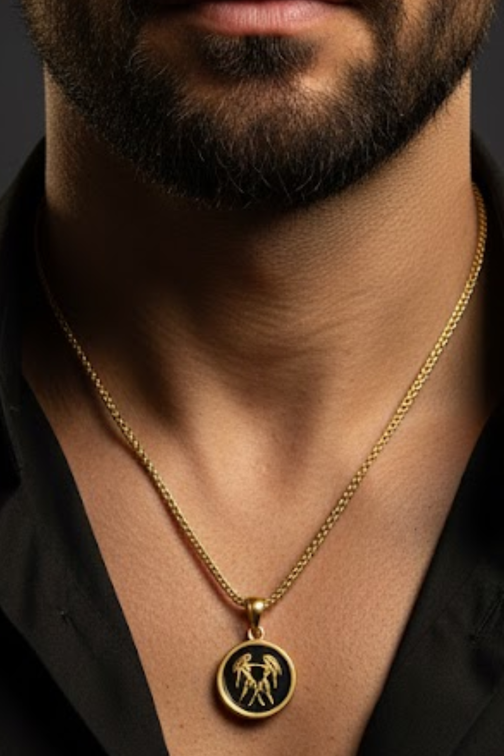 A close-up of a man's neck and chest area, with a gold chain necklace and a pendant featuring a circular design.