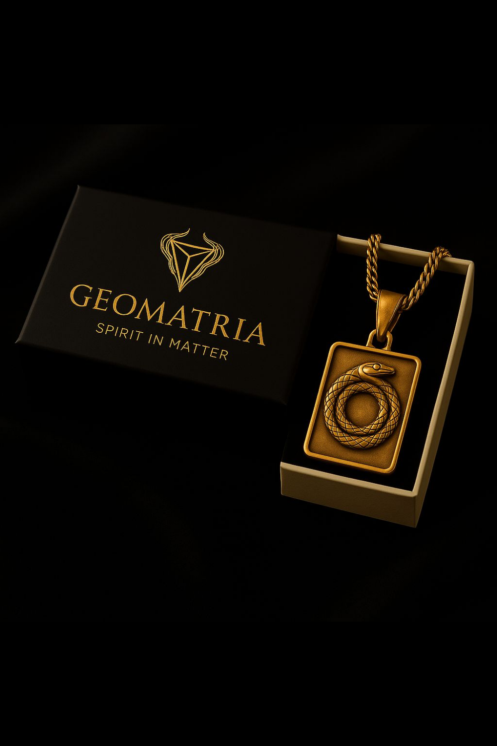 A gold necklace with a pendant is displayed in a black box with the Geomatria logo, accompanied by a gold chain.