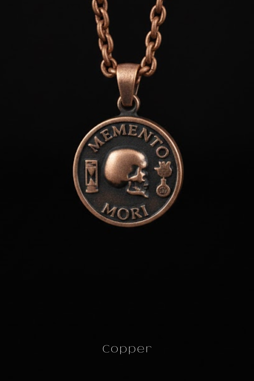 A copper-colored pendant necklace with a circular medallion featuring a skull and the Latin phrase "Memento mori" (The Memory of Death).