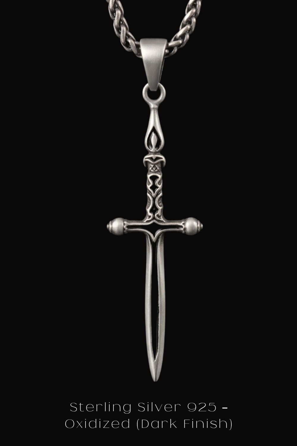 A silver-colored pendant in the shape of a sword with a cross at the bottom, suspended from a chain against a black background.