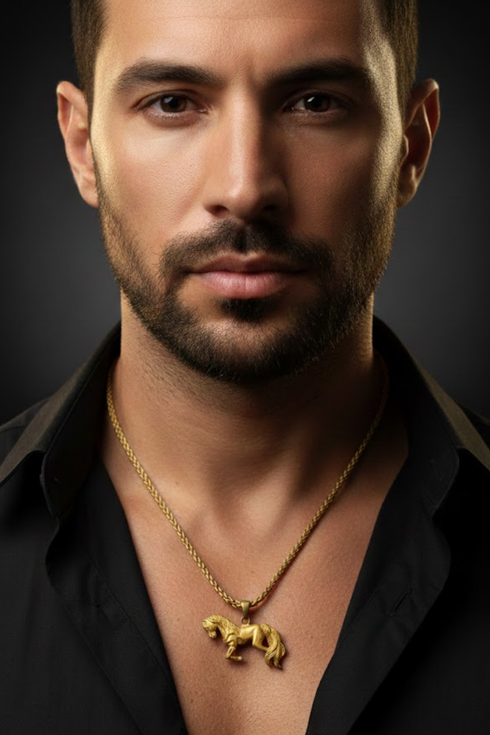 A man with a beard wearing a black shirt and a gold necklace with a pendant.
