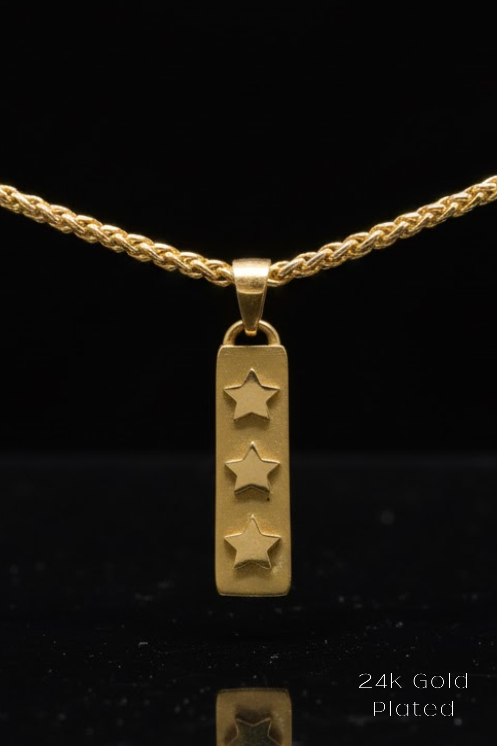 A 24k gold plated pendant with three stars is displayed against a black background.