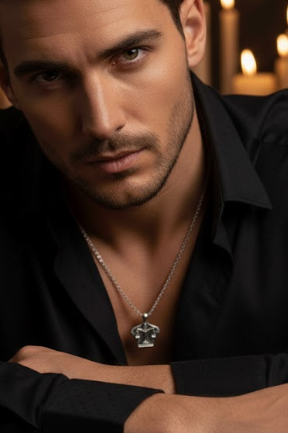 A close-up portrait of a man wearing a black shirt and a necklace, with a serious expression on his face.