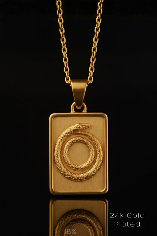 A gold-colored pendant necklace with a rectangular pendant featuring a snake design.