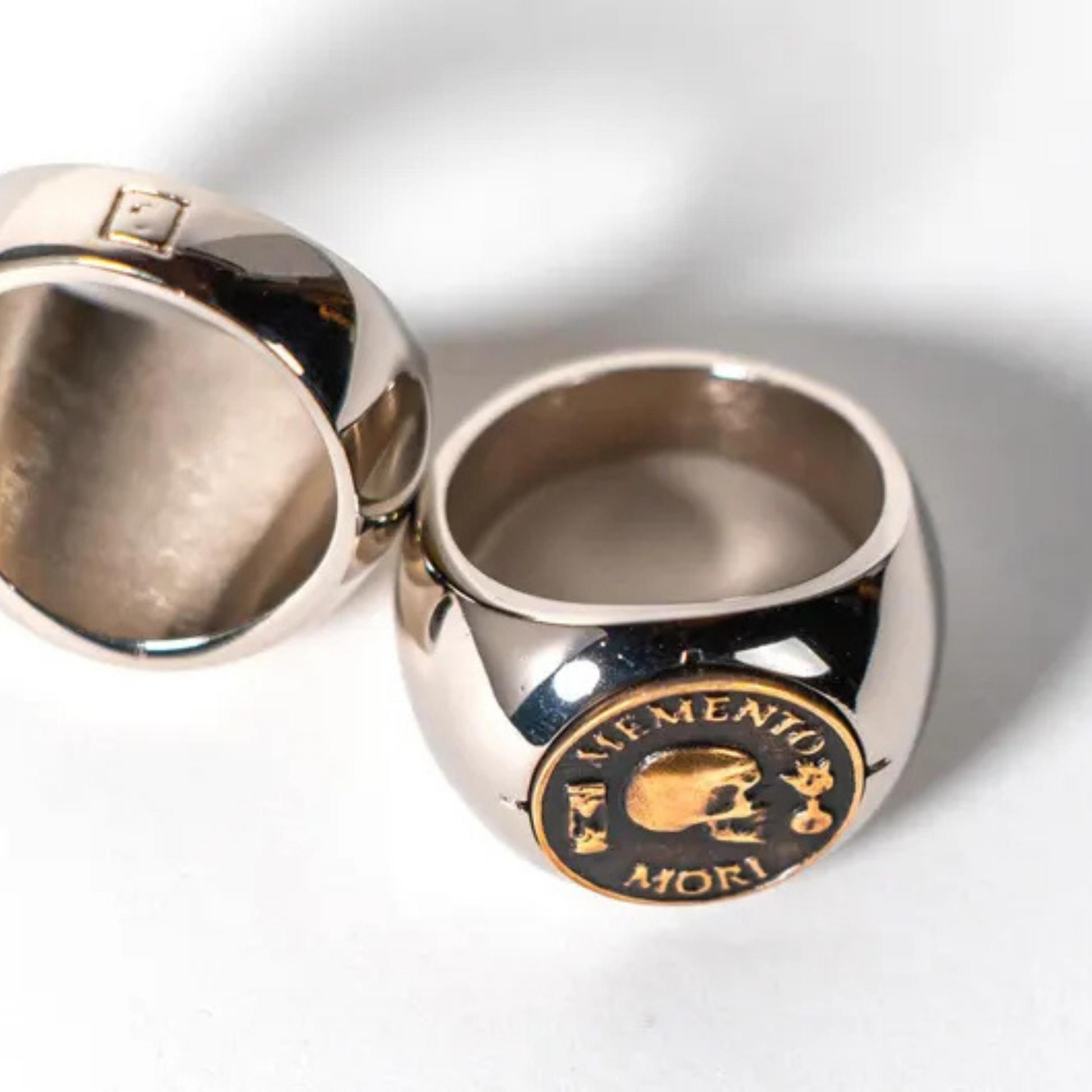 two silver rings with a circular emblem on the front.