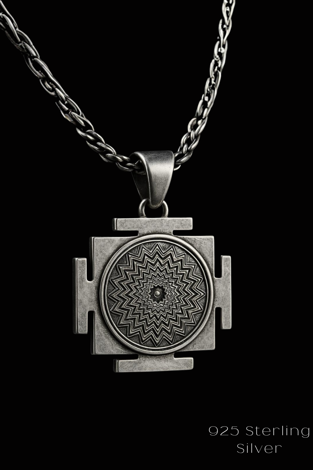 A silver pendant with a geometric design, featuring a central circle surrounded by four triangular shapes, suspended from a chain.