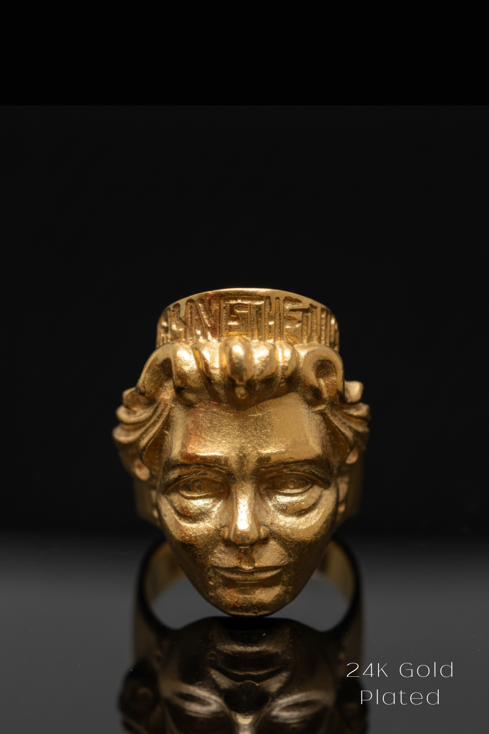 A 24K gold plated ring in the shape of a human head, with intricate details and a crown-like design.