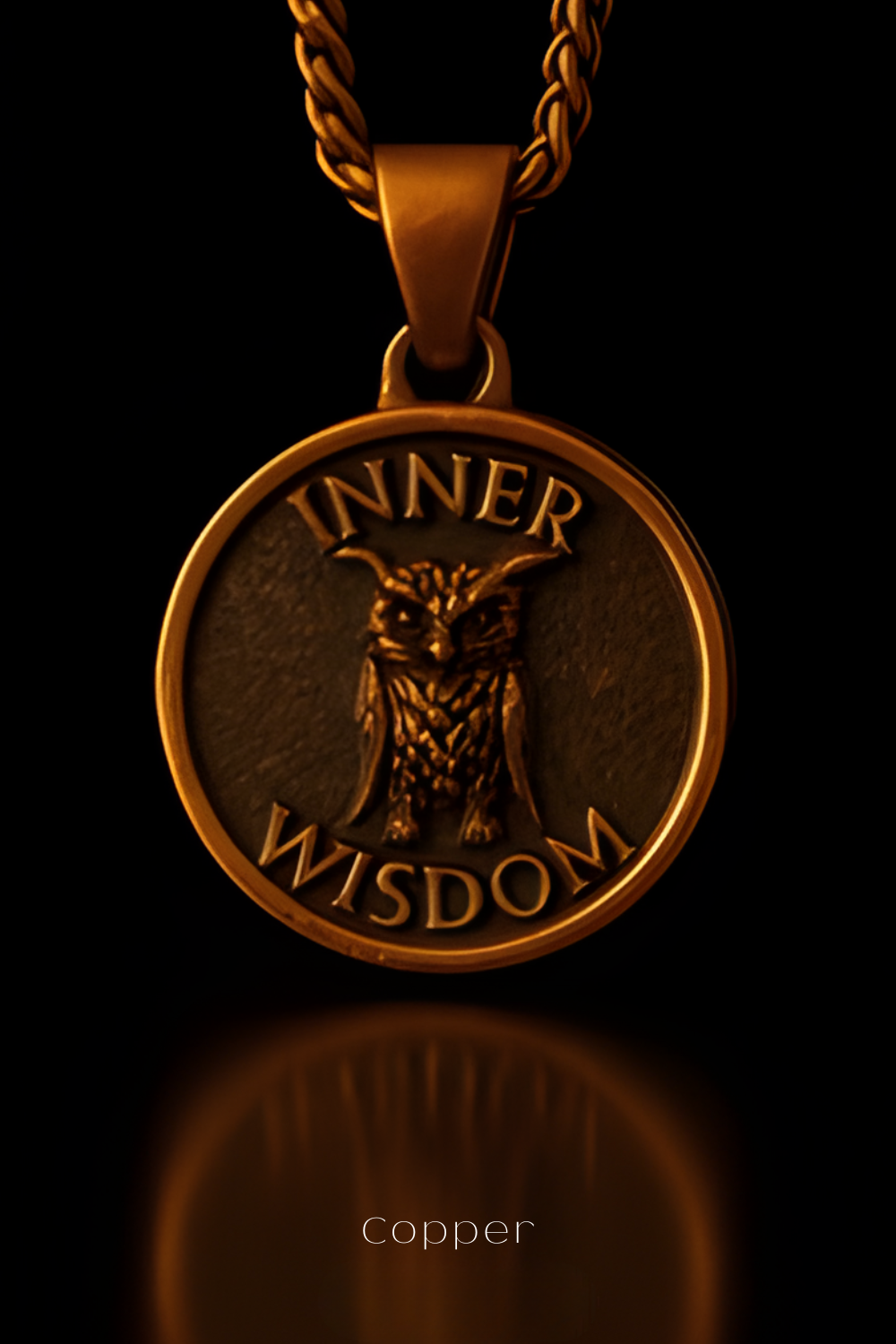 A gold-colored pendant with the words "INNER WISDOM" engraved on it, featuring an owl design.