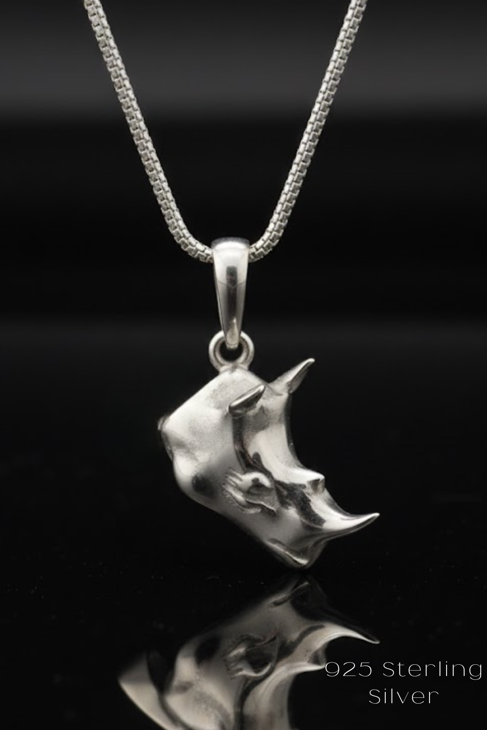 A silver rhinestone pendant necklace with a chain and a pendant featuring a rhinestone design.