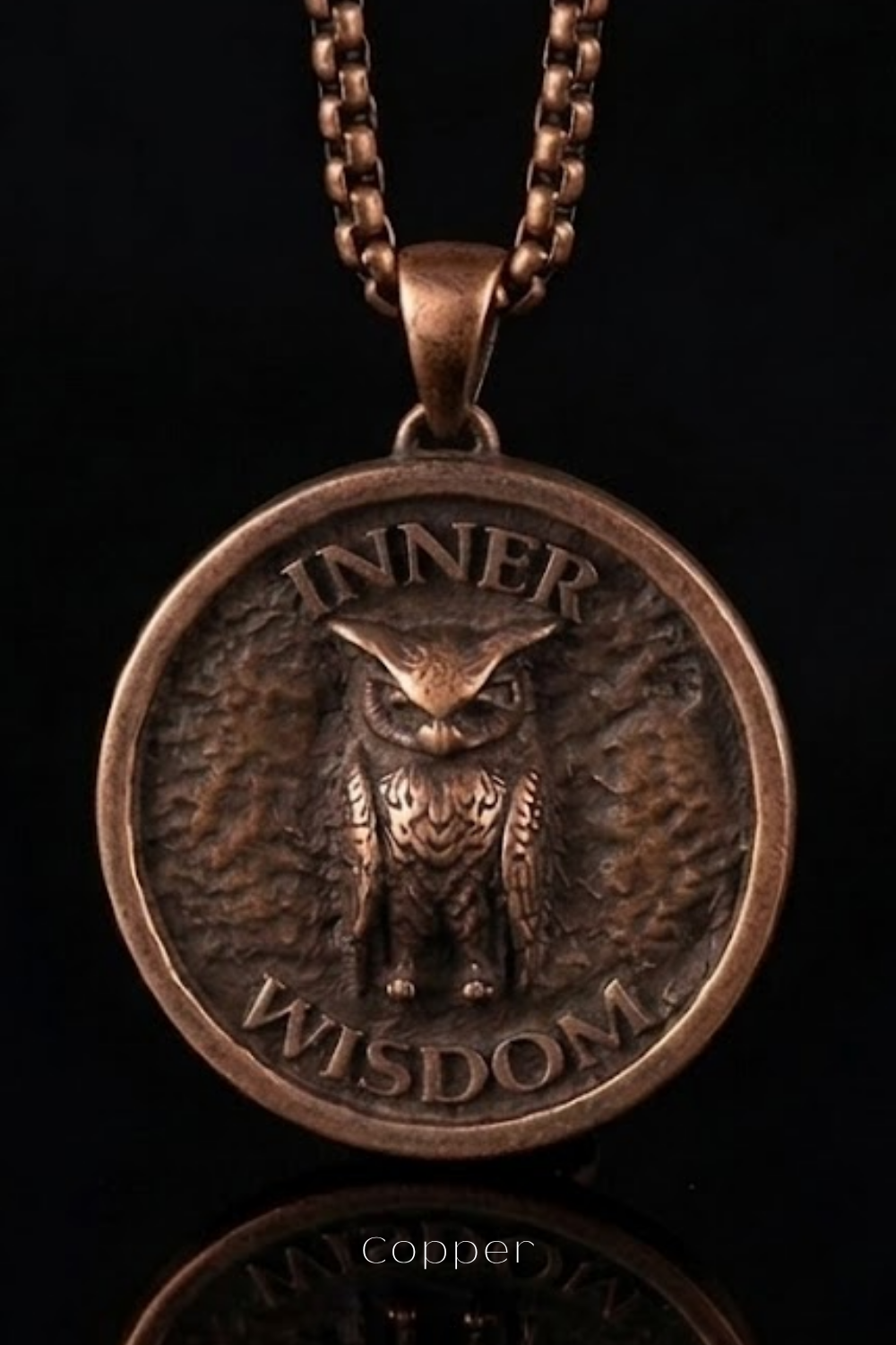 A copper-colored pendant necklace with a circular medallion featuring an owl design and the text "INNER WISDOM" engraved on it.