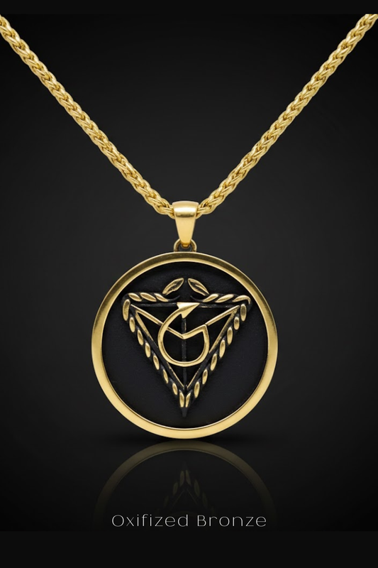 A gold-colored pendant necklace with a circular design featuring a stylized triangle and a leaf-like element.