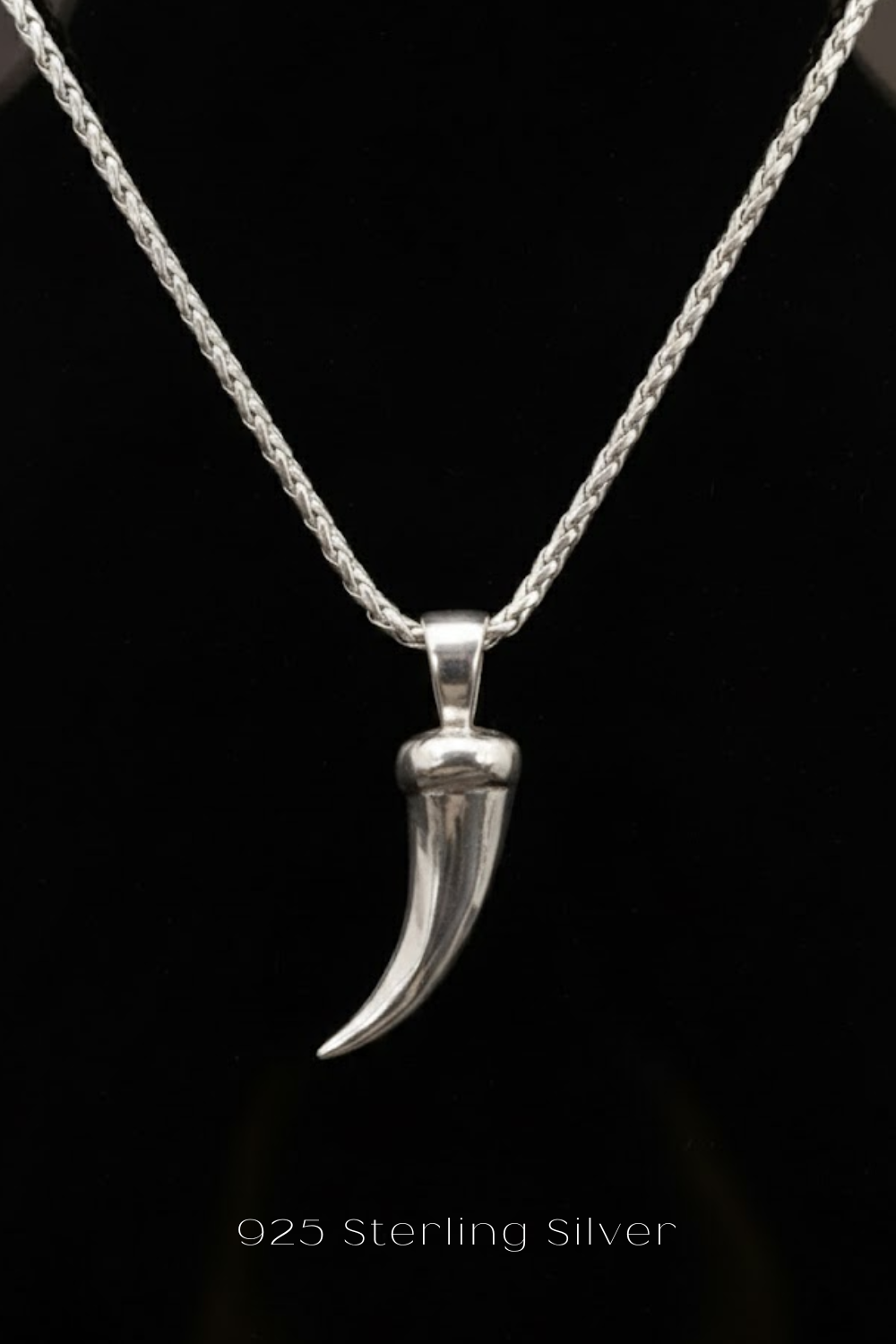 A silver necklace with a pendant featuring a silver horn-shaped design.