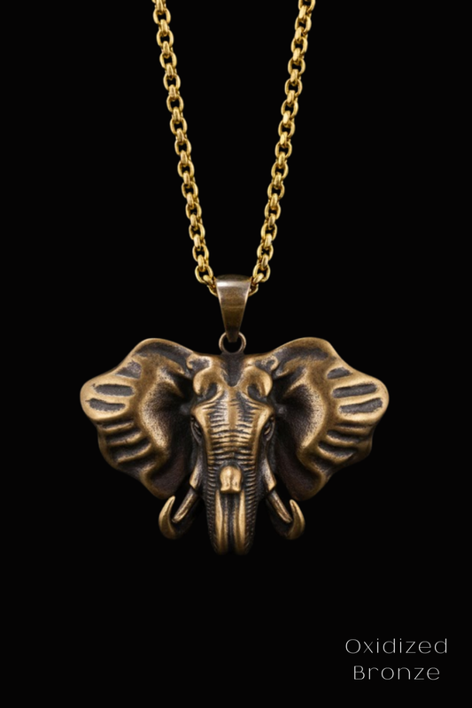 A gold-colored pendant featuring a detailed bronze elephant head design.