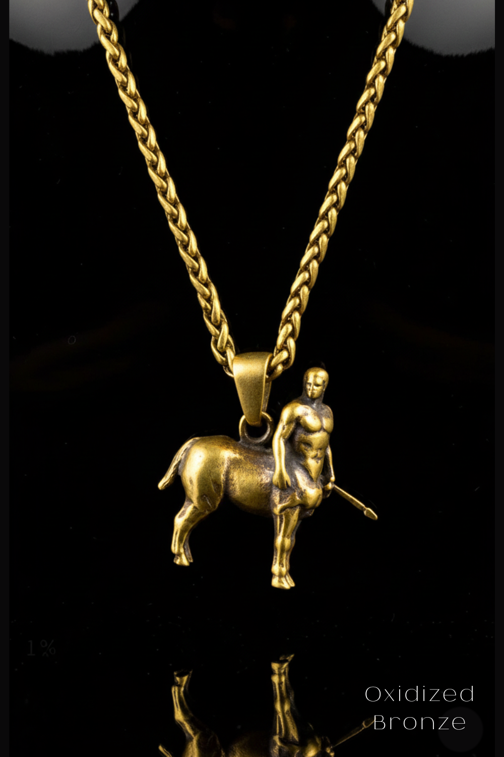 A gold-colored pendant featuring a bronze statue of a man on a rearing horse, suspended from a chain.