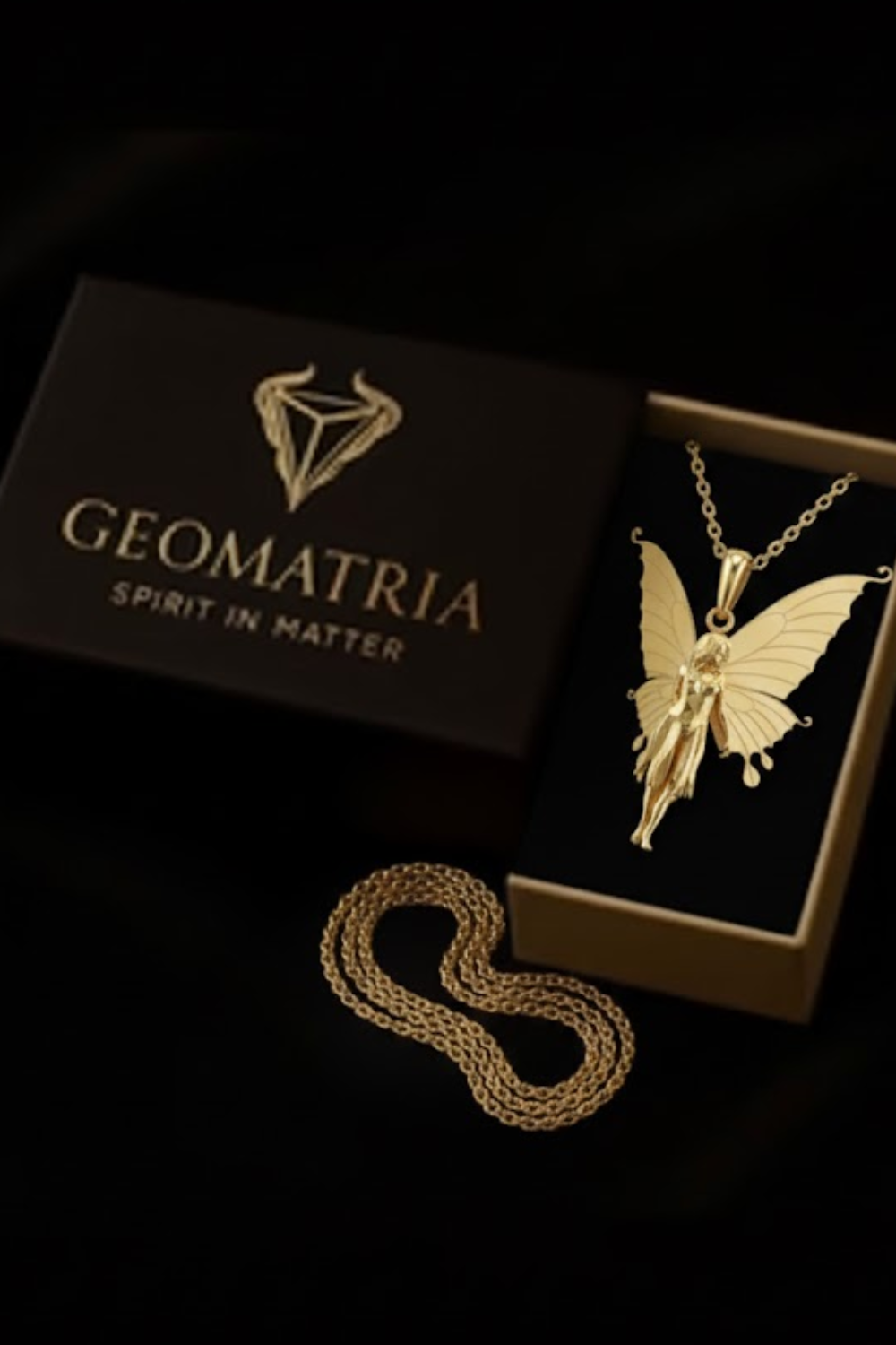 a gold-colored necklace with a butterfly pendant, placed inside a black box with a gold chain.