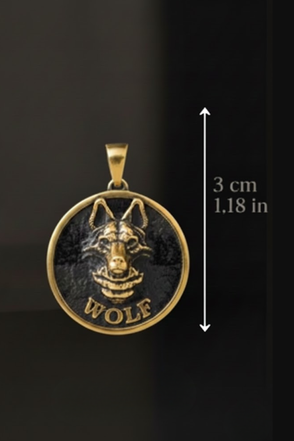 A pendant in the shape of a wolf's head, with the word "WOLF" written below it. The pendant is made of metal and is approximately 3 centimeters in diameter.