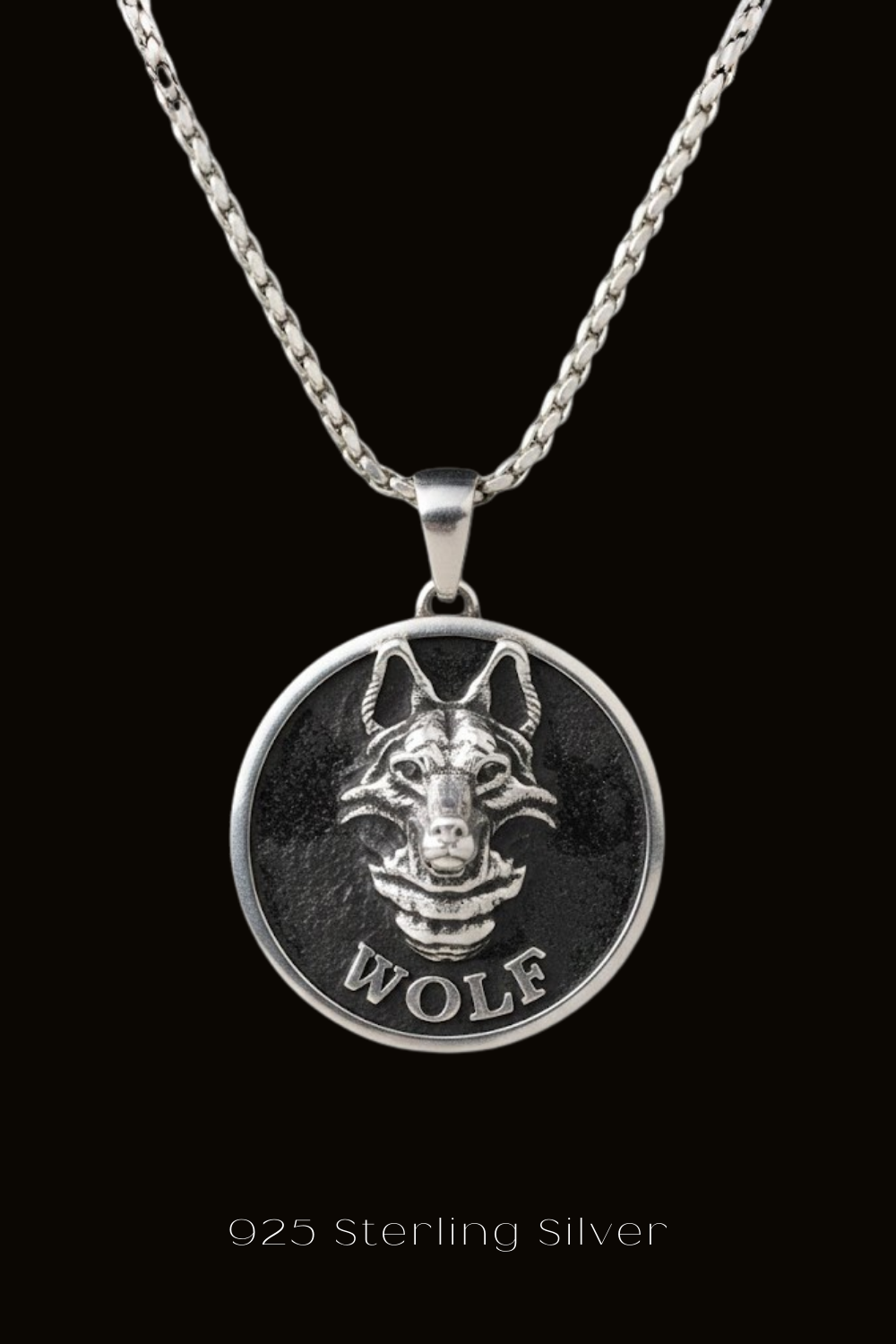A silver pendant necklace with a circular medallion featuring a silver wolf's head design.