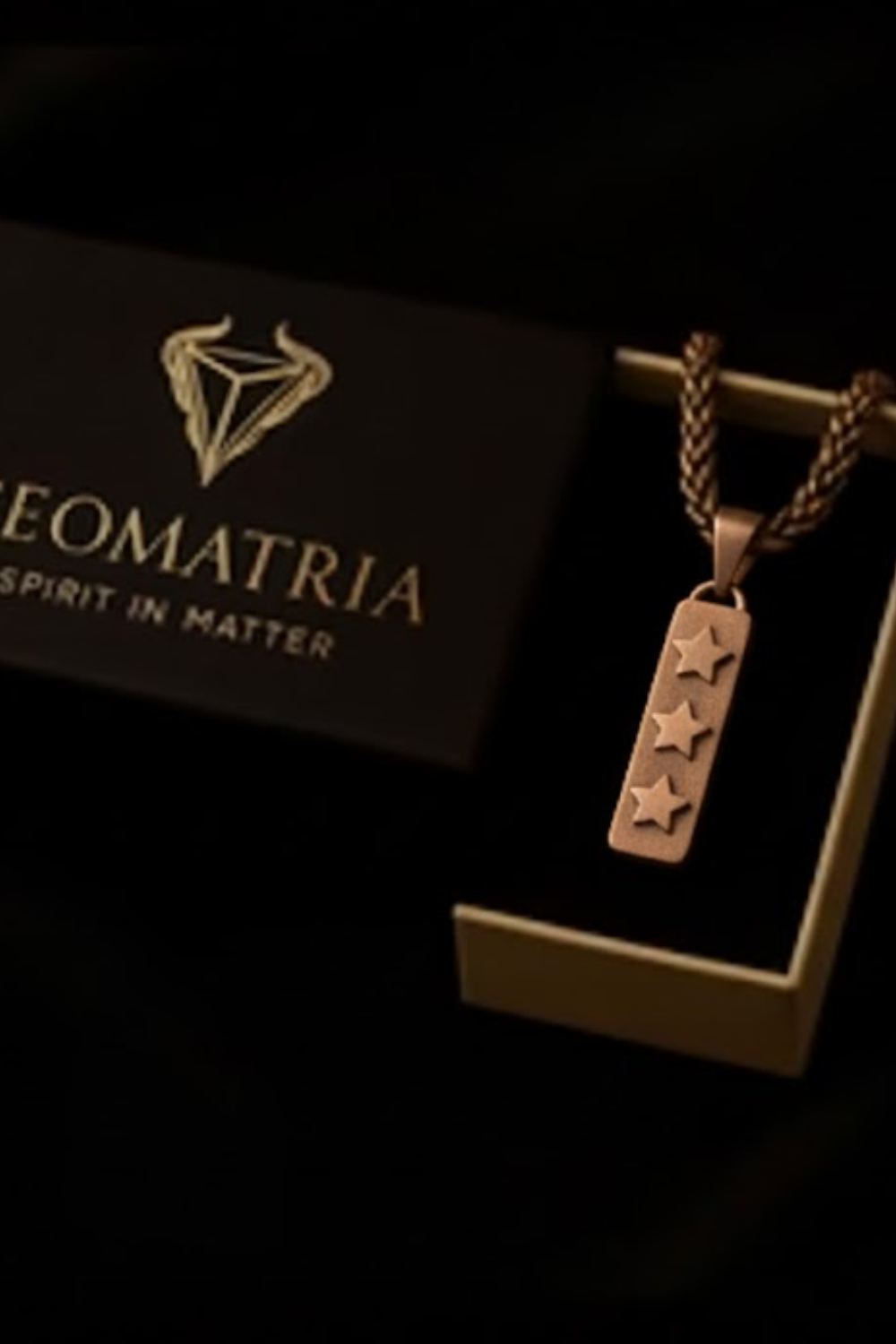 a necklace with a pendant, displayed in a black box with gold lettering.