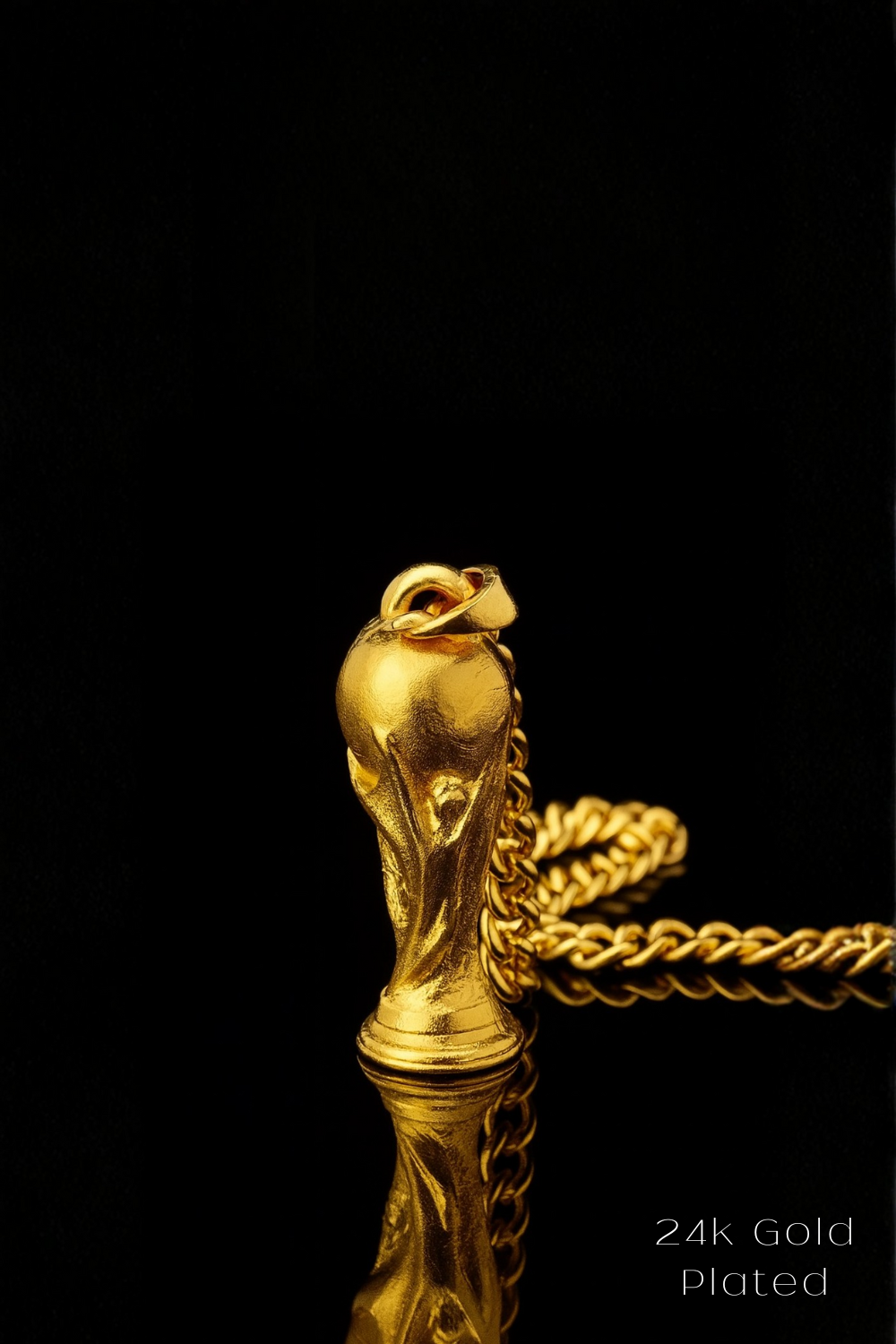 A gold-plated pendant in the shape of a trophy or cup is displayed against a black background, with a chain visible.
