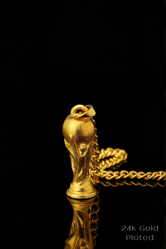 A gold-plated pendant in the shape of a trophy or cup is displayed against a black background, with a chain visible.