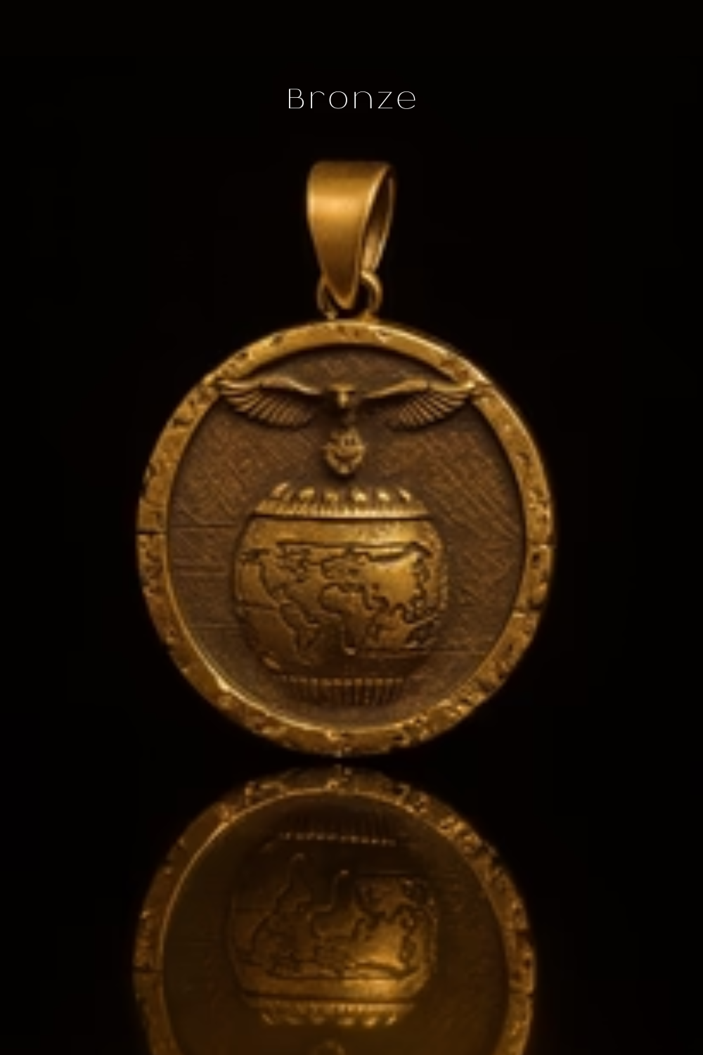 A gold-colored pendant with a detailed design, including a globe and an eagle, is displayed against a black background.