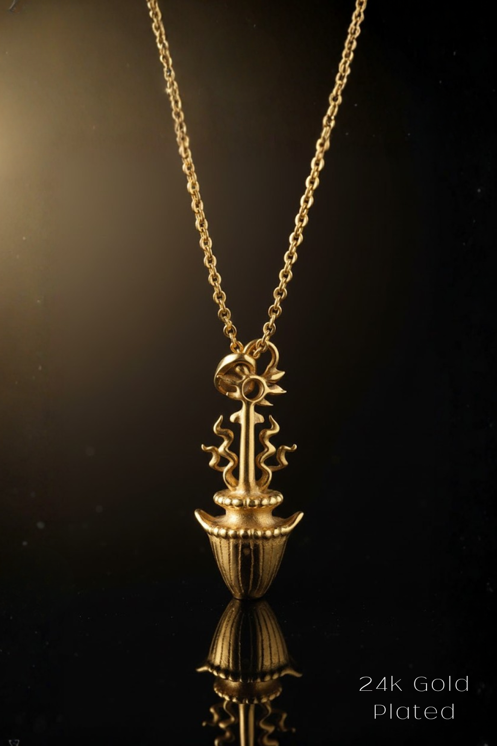 A gold-plated necklace with a pendant featuring a stylized floral design.