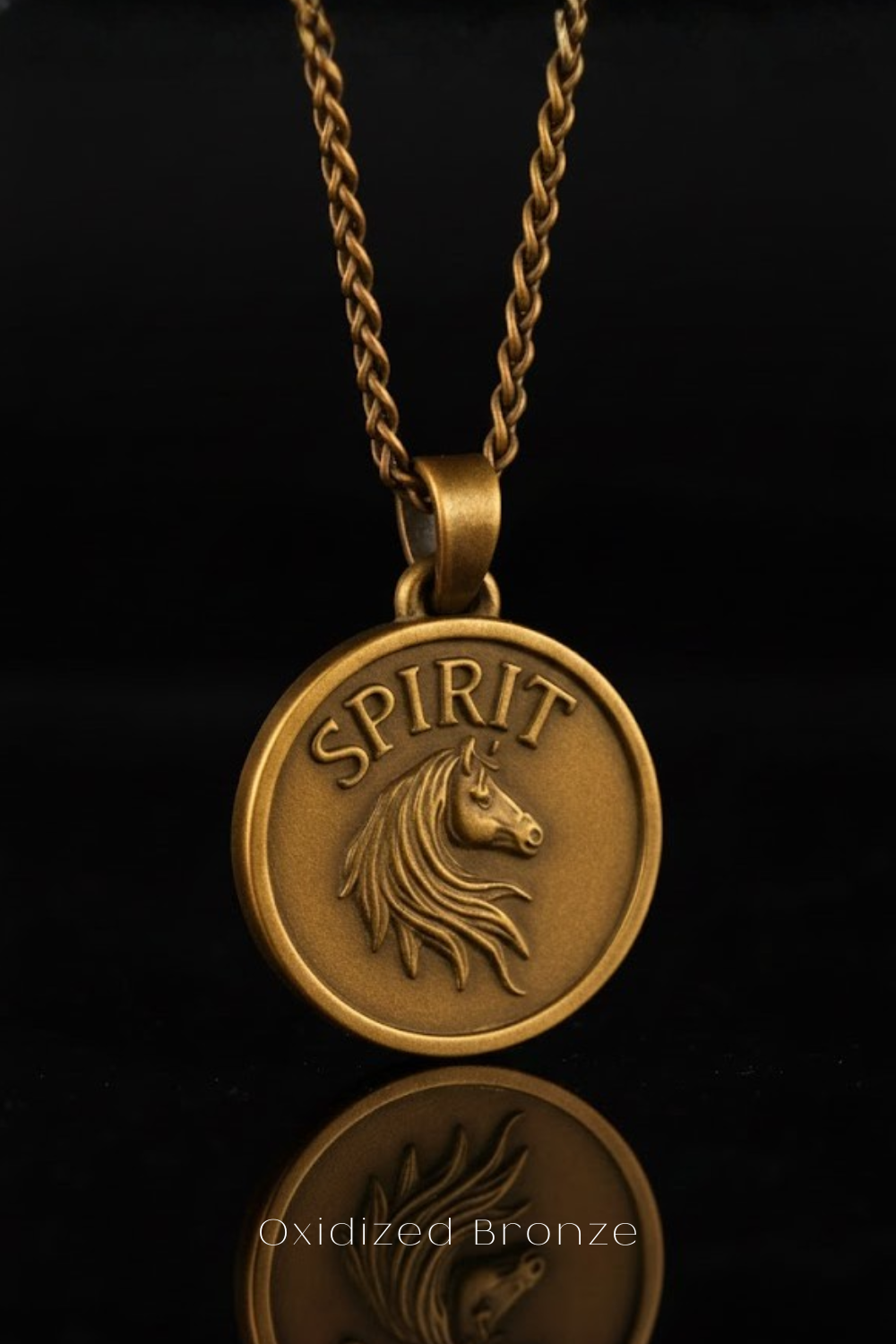 A gold-colored pendant necklace with a circular medallion featuring a horse's head and the word "SPIRIT" engraved on it.