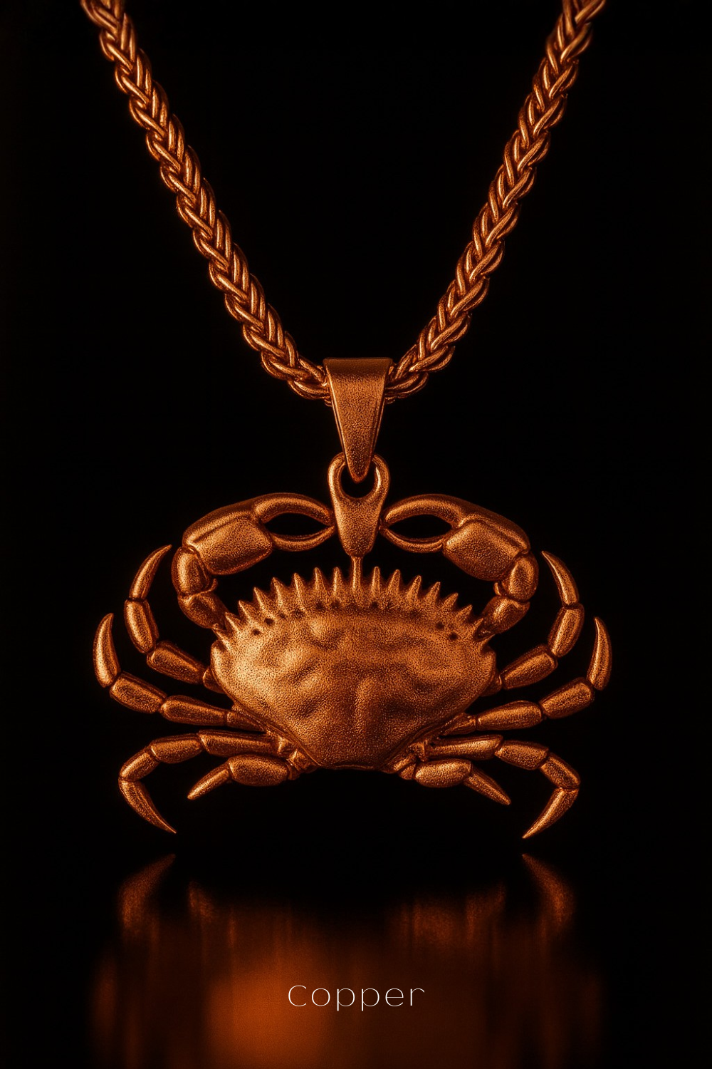 A copper-colored pendant in the shape of a crab is displayed against a black background.