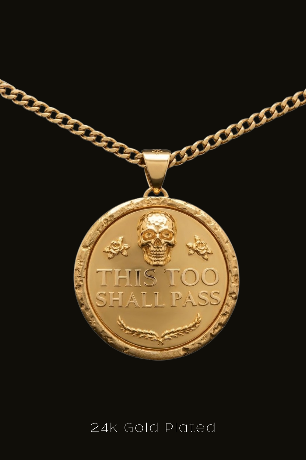 A 24k gold-plated pendant necklace with a circular medallion featuring a skull and the text "THIS TOO SHALL PASS" engraved on it.
