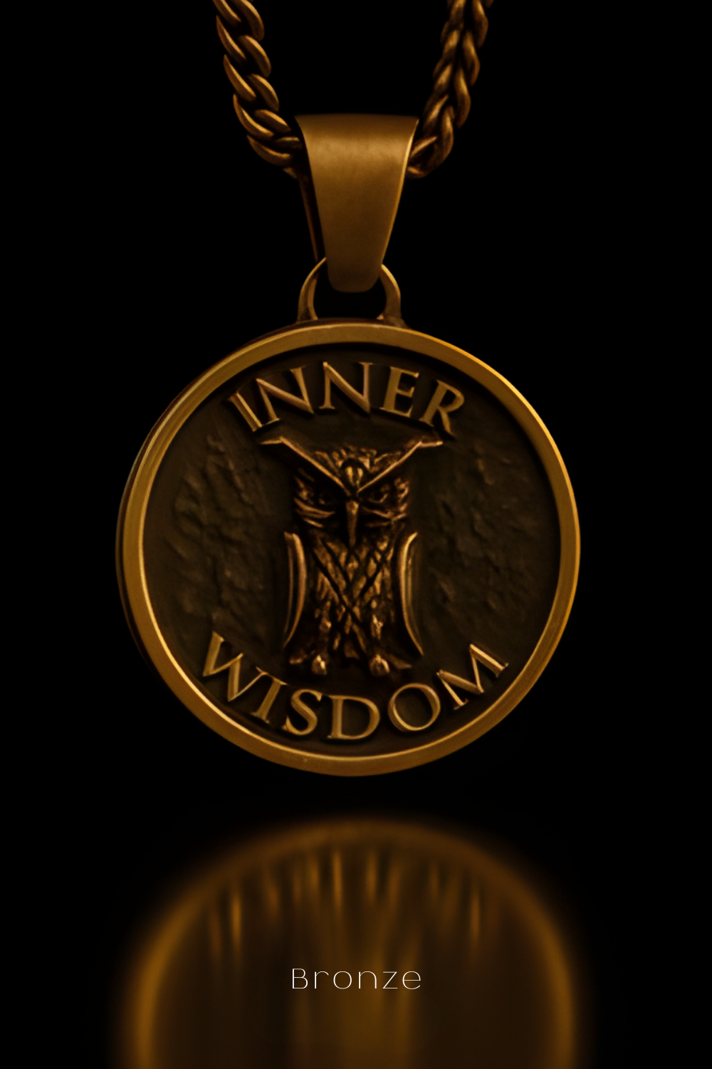 A gold-colored pendant with the words "INNER WISDOM" engraved on it, featuring an owl design.