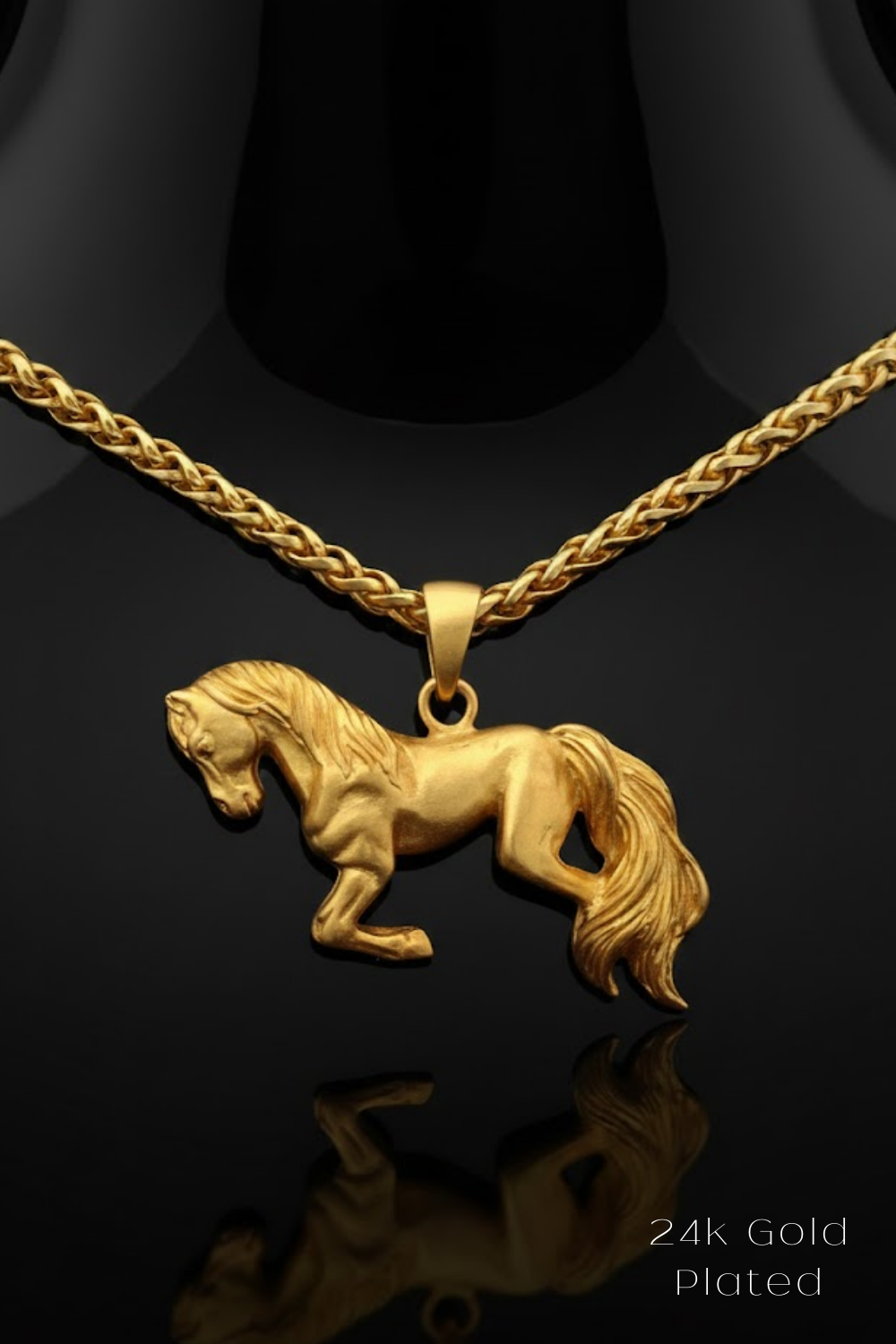 A 24k gold plated pendant in the shape of a horse is displayed against a black background.
