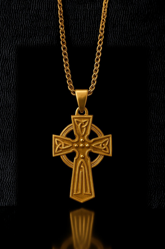 A gold cross pendant with intricate designs is displayed against a black background.