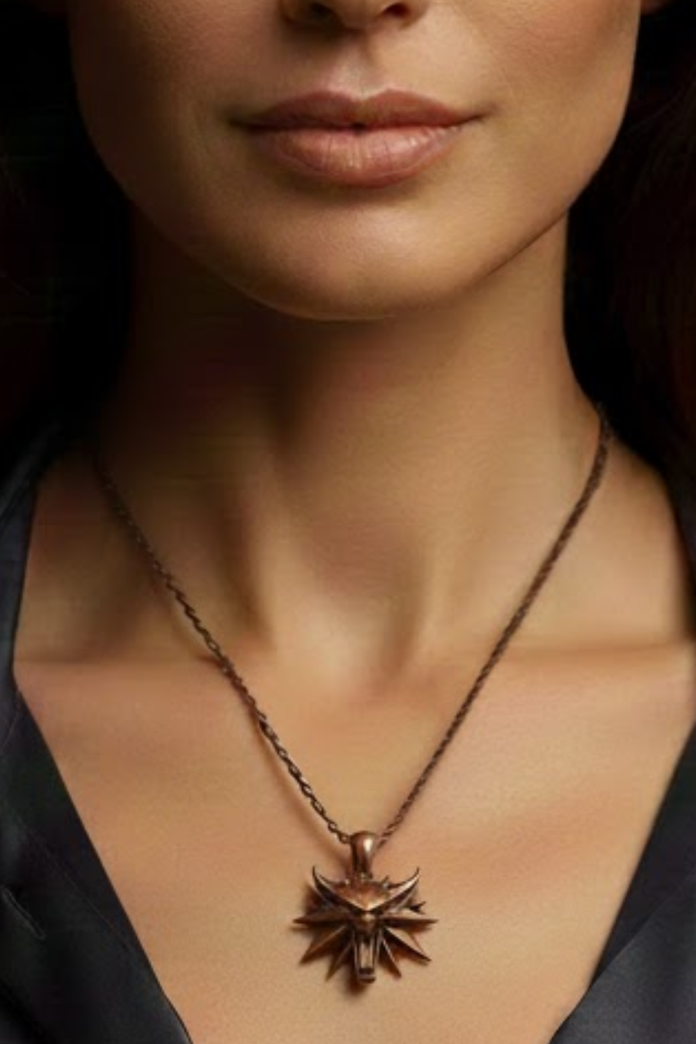A close-up of a woman's neck and chest area, with a pendant necklace featuring a distinctive design.