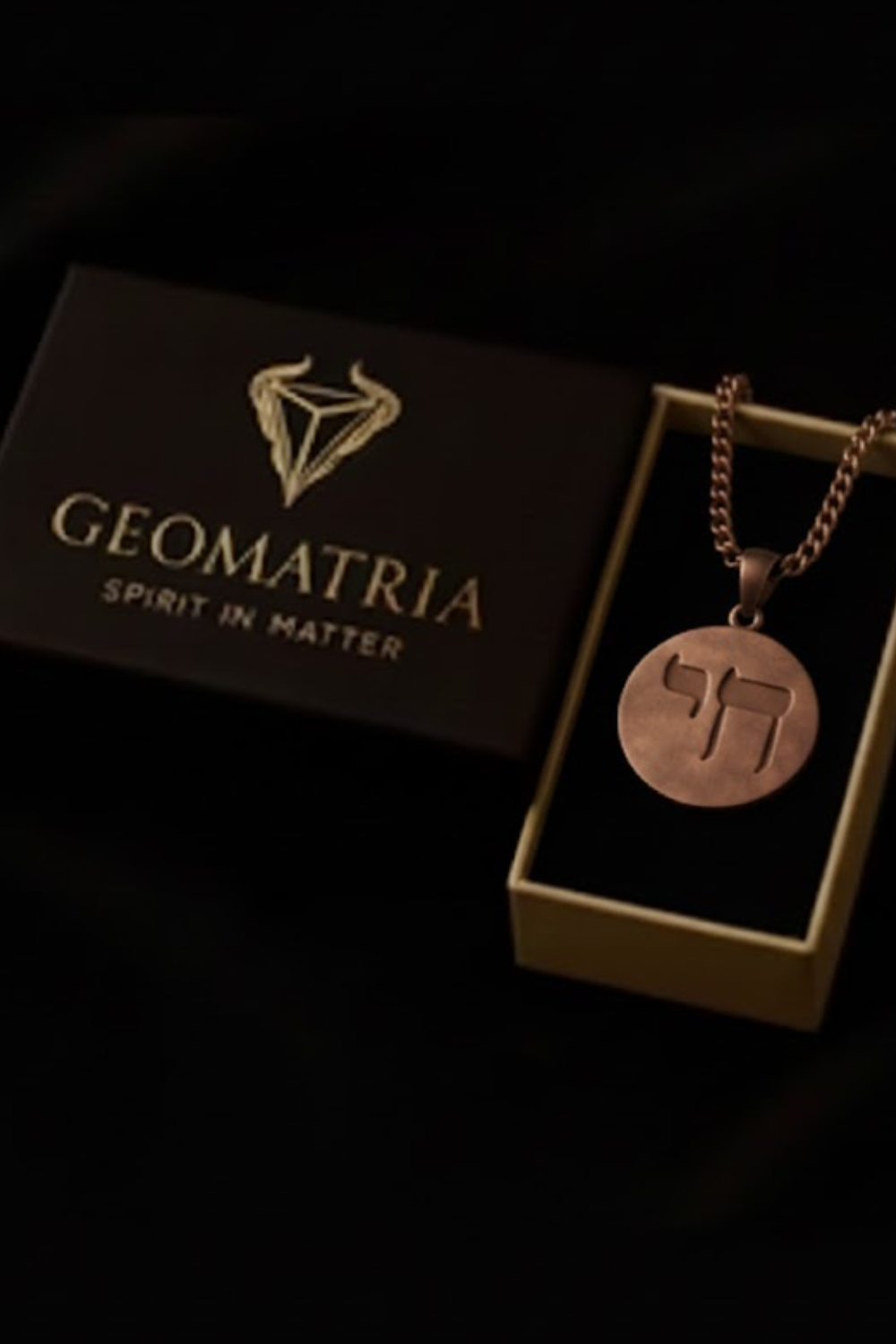 a necklace with a pendant, placed inside a box with a geometric design.