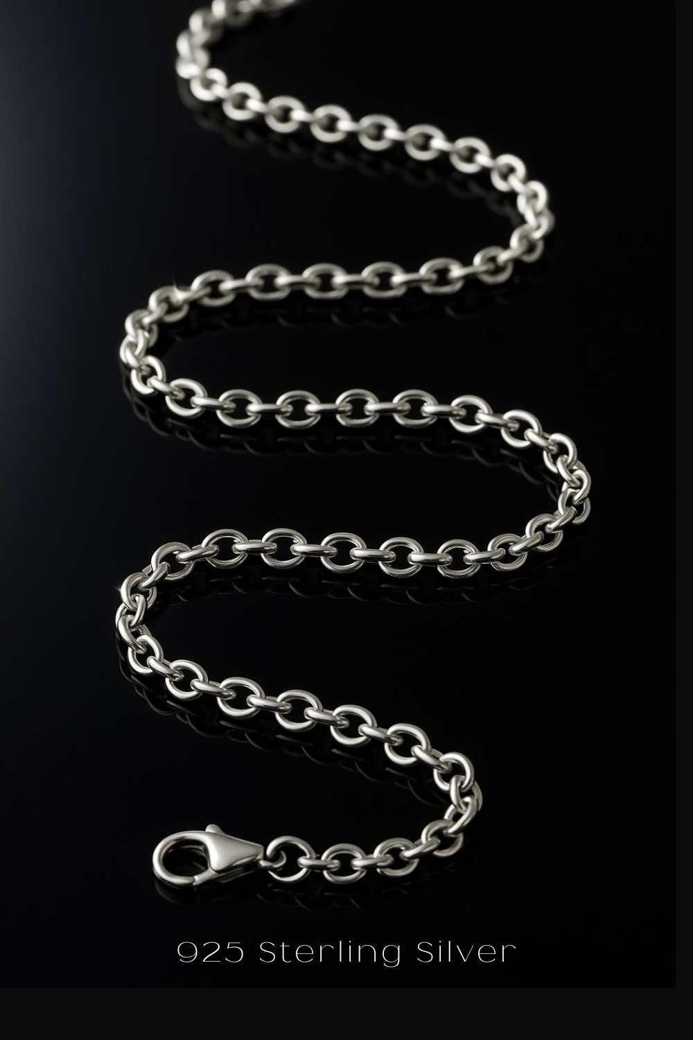A silver chain necklace with a clasp is shown against a black background.