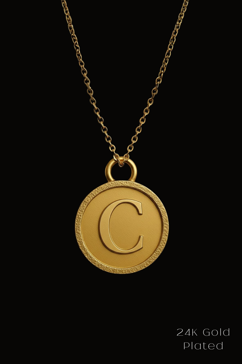 A 24K gold plated necklace with a large, round, engraved letter 'C' pendant.