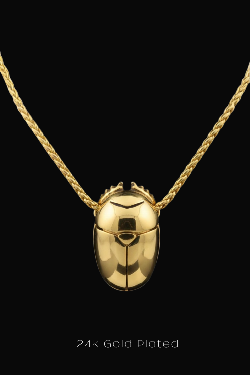A 24k gold-plated pendant in the shape of a beetle is displayed against a black background.
