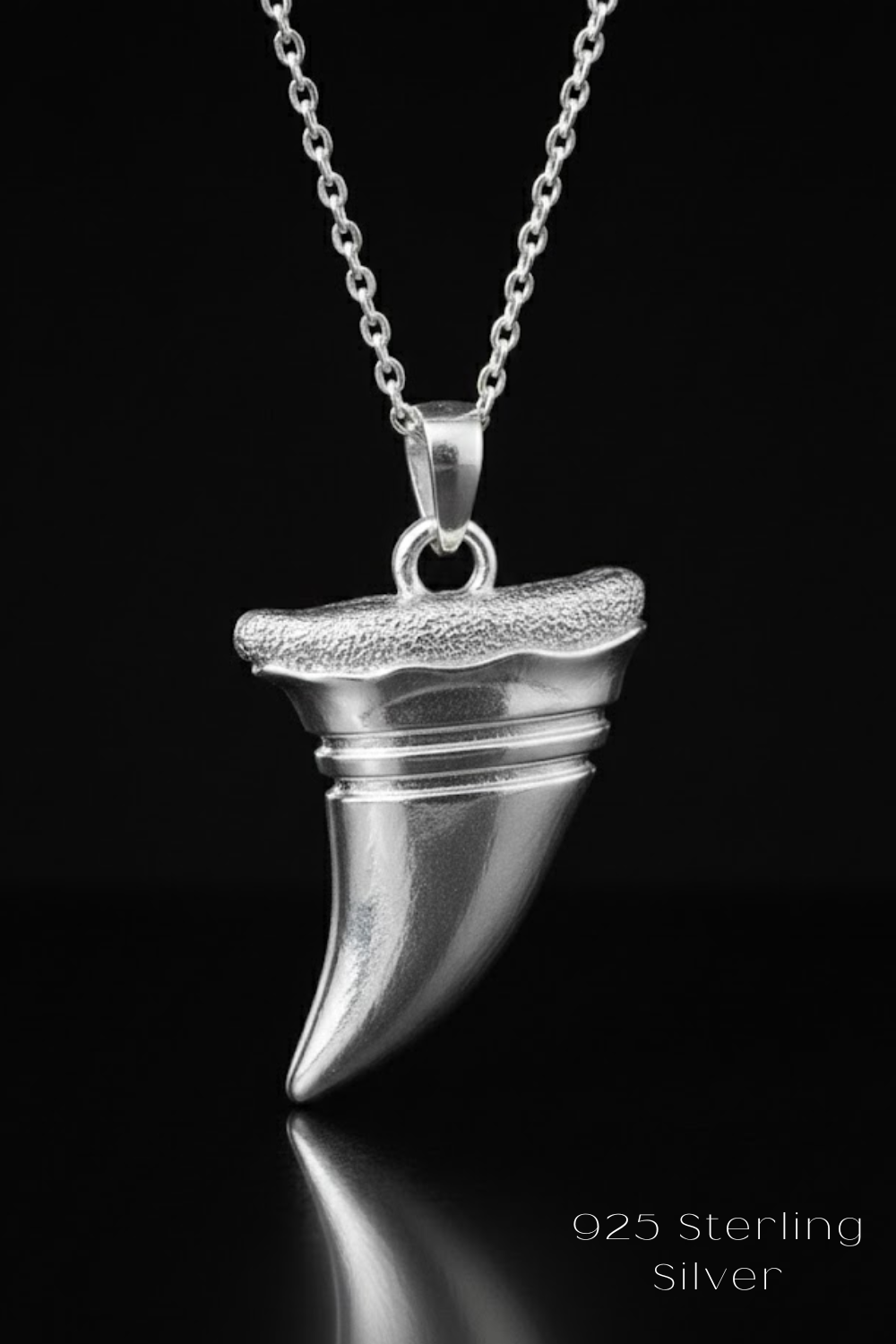 A silver pendant necklace with a silver-colored pendant against a black background.
