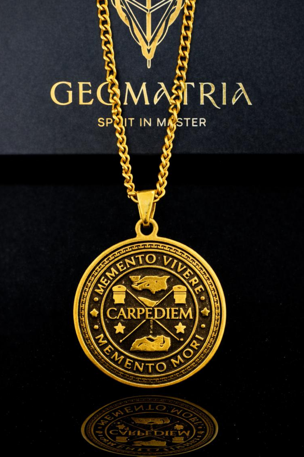 A gold-colored pendant necklace with a circular medallion featuring Latin text and symbols, displayed against a black background.