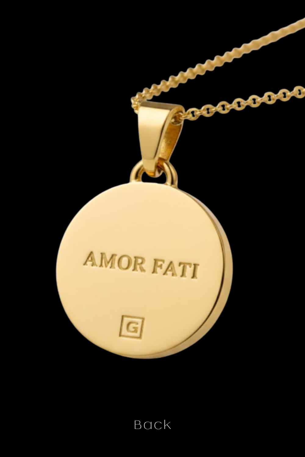 a gold-colored pendant with the engraved text "AMOR Fati" on it.