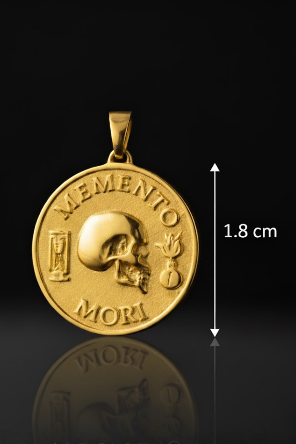 a gold-colored pendant with a skull and the Latin phrase "Memento mori" (which means "Remembering the dead" in English). The pendant is approximately 1.8 centimeters in diameter.