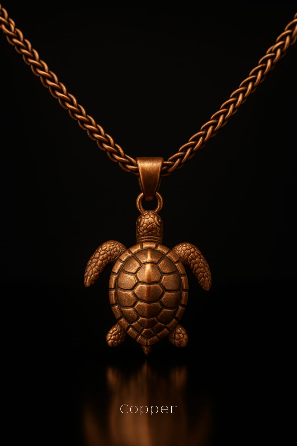A copper-colored pendant in the shape of a turtle is displayed against a black background, with a chain around it.