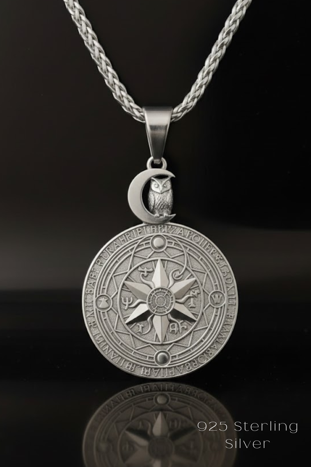 A silver pendant necklace with a circular medallion featuring an owl and a crescent moon design, suspended from a silver chain.