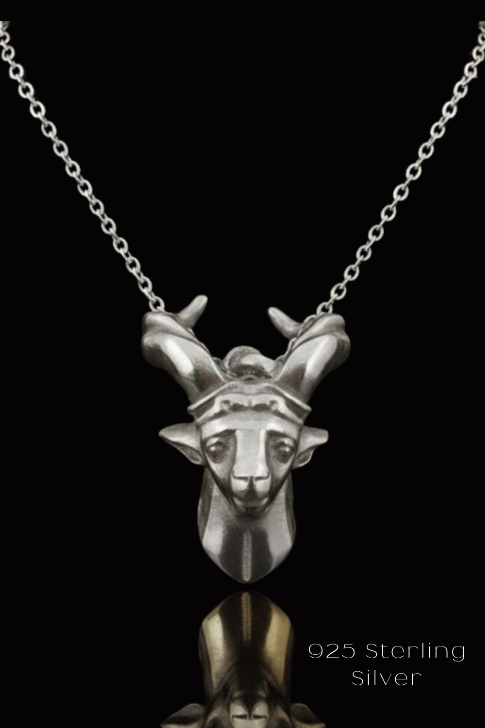 A silver pendant necklace with a detailed silver goat head pendant against a black background.
