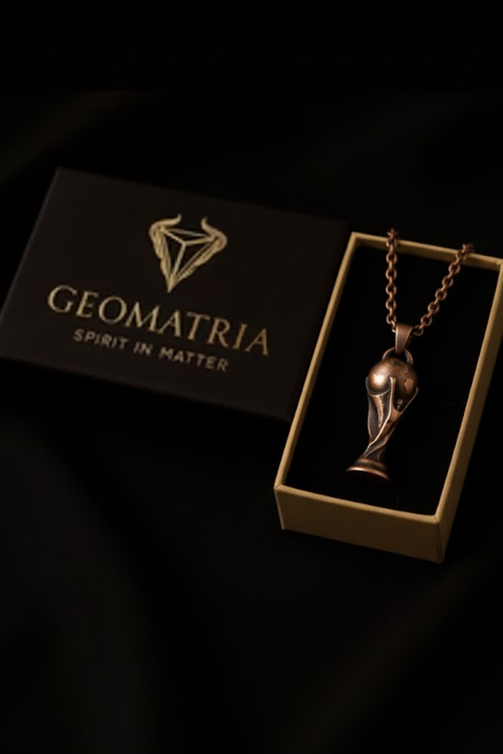 A necklace with a pendant is displayed in a box, which is labeled "Geomatria Spirit in Matter".
