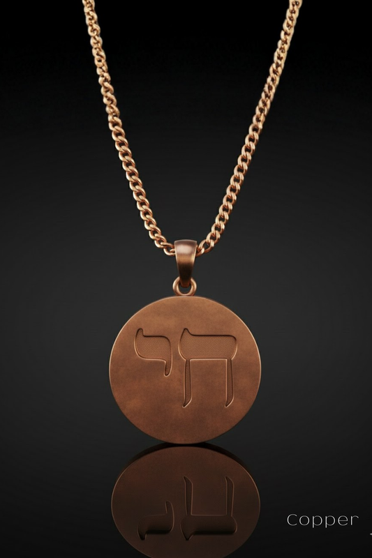 A copper-colored pendant necklace with a circular medallion featuring a stylized symbol, such as a stylized letter or symbol, hanging from a chain.
