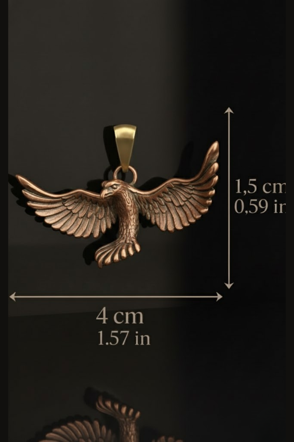 A detailed image of a pendant in the shape of a bird, specifically an eagle, with wings spread wide. The pendant is made of a shiny material, possibly brass or bronze, and is displayed against a black background. The image also includes measurements indicating the size of the pendant, with the dimensions being 4 cm by 1.57 inches.